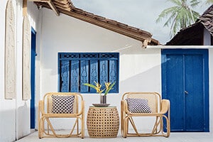 Facade of property with cane outdoor seating for property investors