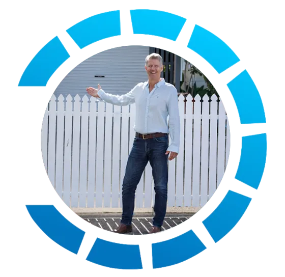 Buyers Agent Brisbane Joerg Muller Joerg Mueller, Buyers Agent Brisbane standing outside a white picket fence in blue jeans and light blue linen shirt