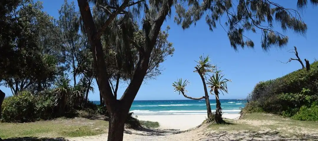 Beach QLD Moving to Queensland with white sand and blue sky