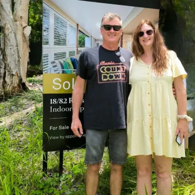 Happy Buyers Scout clients Roxanne and Allan in front of Sold sign